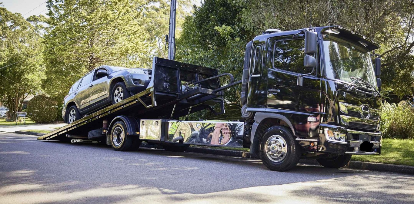 Professional flatbed towing service safely transporting vehicle in Poway
